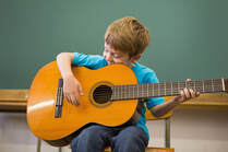 Boy posing during a guitar lesson.