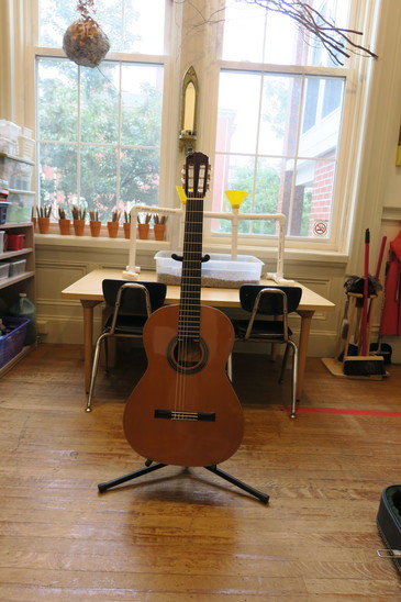 Classical guitar on a guitar stand in guitar lessons room.